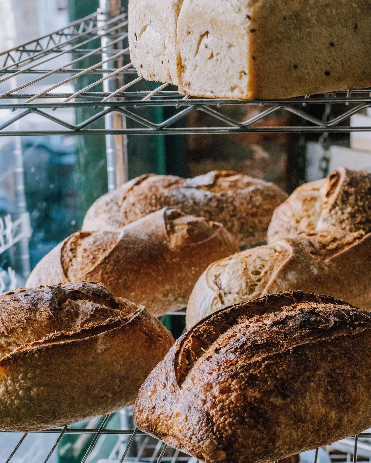 A busy Au Gourmand Boulangerie market stall stacked with loaves and pastries