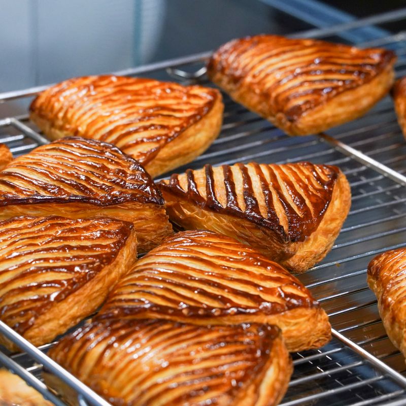 Glazed, scored apple chausson turnovers on a cooling rack
